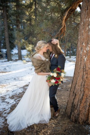 Bride and Groom at Red River wedding in forest with wintertime bouquet