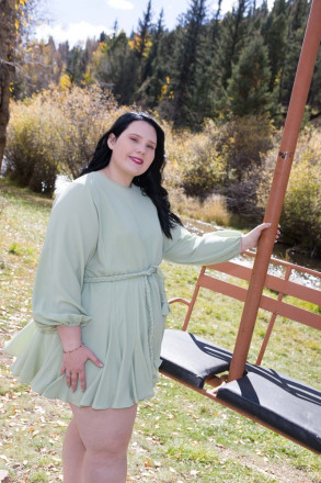 High school senior poses with old ski lift in Red River for senior pictures