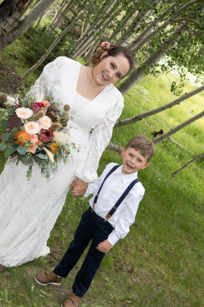 Scarlett holds the ring bearers hand before the wedding ceremony