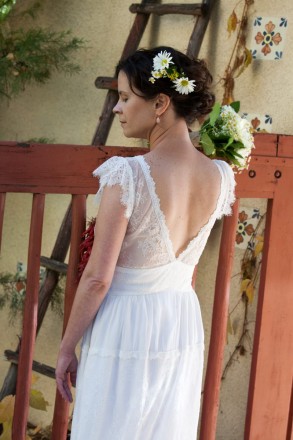 Devon and the back of her September wedding dress and hair up with daisies in the up-do