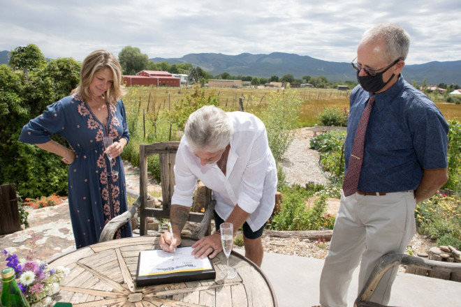 Susan and JR sign the marriage certificate with officiant and minister Dan Jones