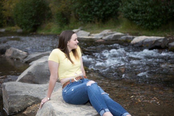 Katie sits next to The Red River in it's namesake town in New Mexico