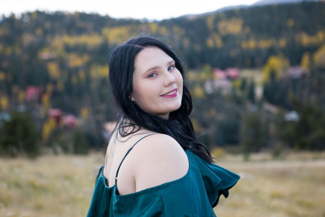 Senior portraits in Red River with autumn foliage in background