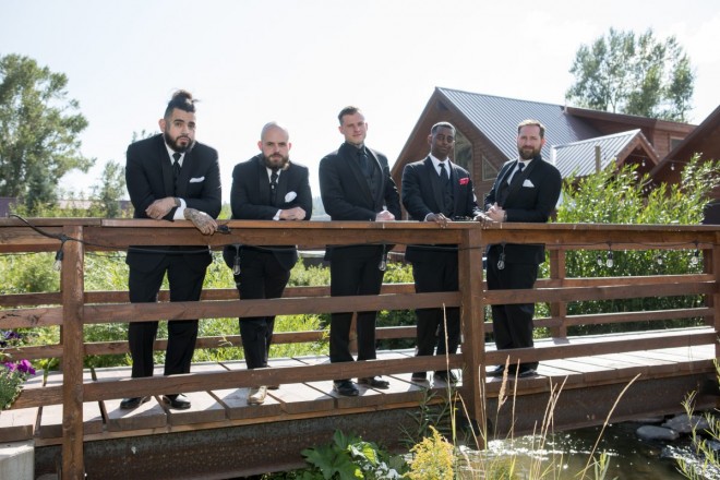 Groom and his groomsmen on bridge before wedding ceremony