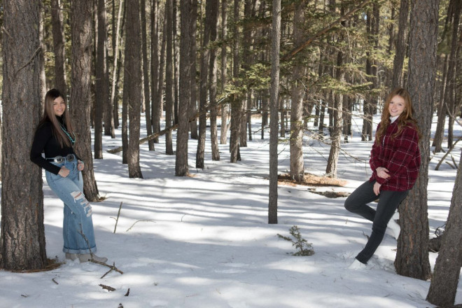 Sisters as opposite as yin and yang pose across from one another in Carson National Forest