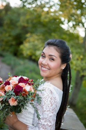 Sarah holds her rose bouquet with autumn colored highlights