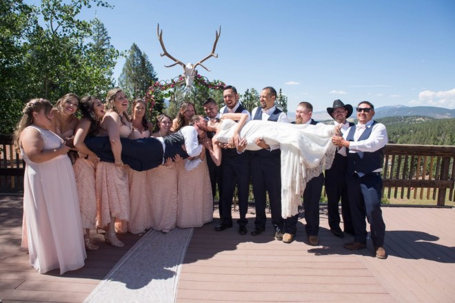 Thirteen person wedding party wearing blush and navy blue hold Monica and George for a wedding kiss!