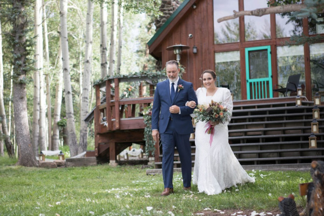 Scarlett's father walks her down a lantern lined aisle