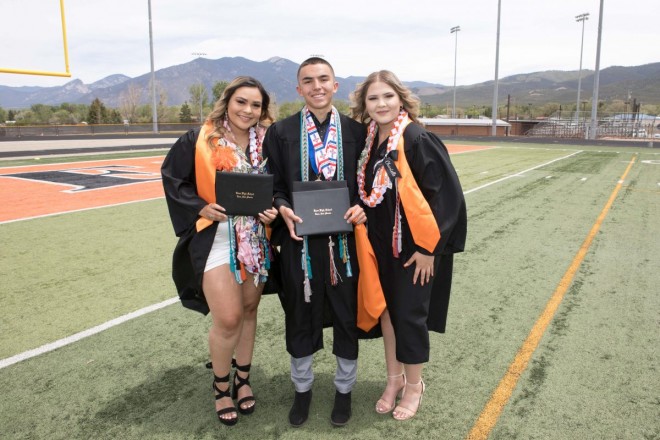 Taos high school graduates after graduation with Taos mountain