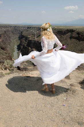Beautiful bride spins in her dress with the Rio Grande Gorge Bridge adorning the background