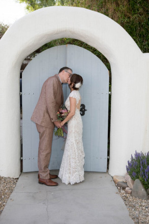 Lindsay and John share a wedding kiss in front of The Love Apple