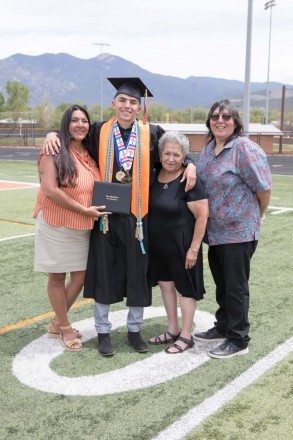 Taos High School graduate with his family and Taos mountain