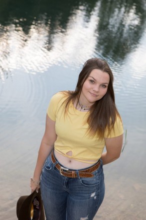 Katie's senior photos in front of a pond with reflections of pine trees