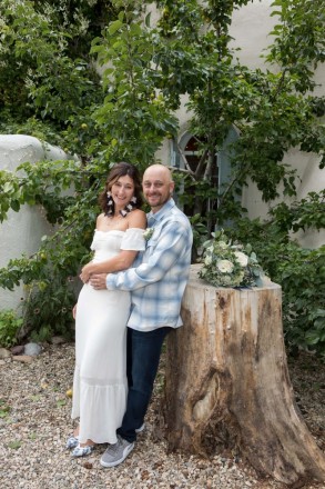 Newlyweds at their wedding restaurant with old stump and apple tree background