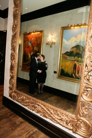 Newlyweds' kiss captured in a mirror reflecting Native American art