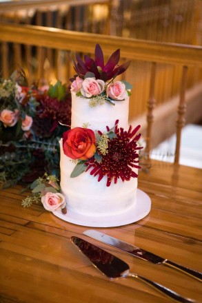Wedding cake adorned with autumn flowers for October wedding