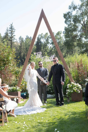 Courtney flashes peace sign to her guests after the couple is announced