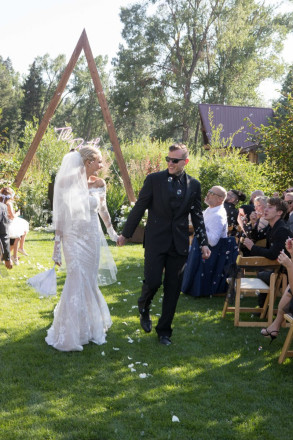 Courtney and Travis smile during wedding recessional