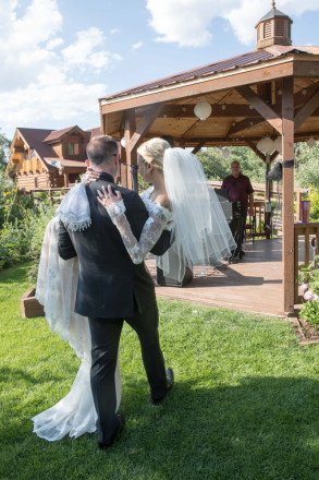 Groom, Travis, carries his bride at South Fork wedding