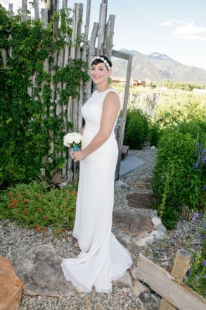 Bride with small bouquet with turquoise accents in front of sacred Taos Mountain