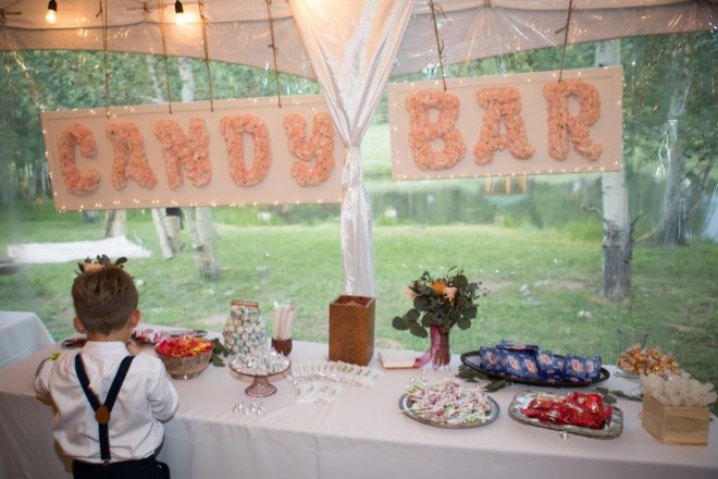 the ring bearer keeps a good eye on the Taos Canyon wedding reception candy bar