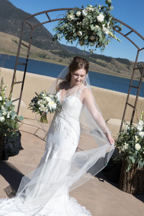 Victoria smiles as she tries to tame her French veil at a windy October wedding