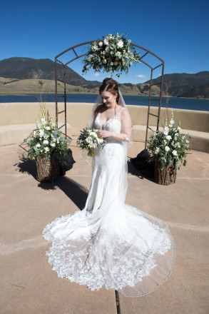 Victoria plays with the top of her wedding bouquet and smiles for a photo