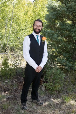 Local Taos groom wears a turquoise tie and hiking boots