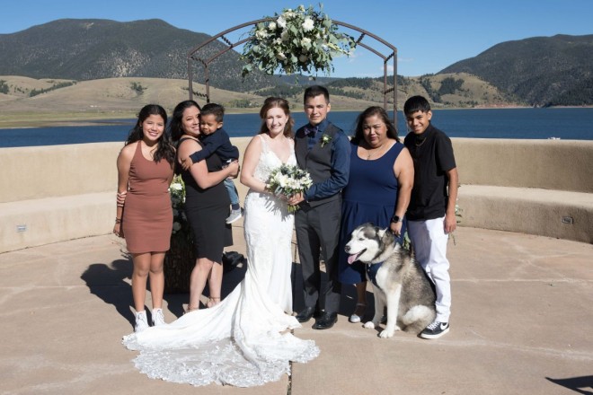 Victoria and Israel have an extended family photo at the altar, dog included