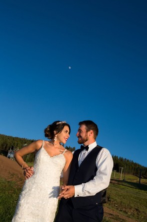 Monica and George with New Mexico blue skies and the moon on the ski lift in Angel Fire.
