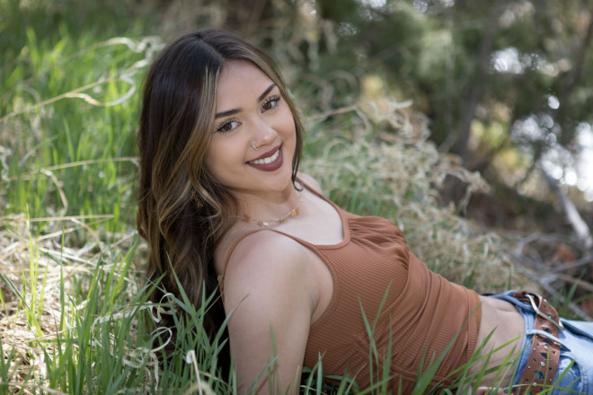 Jenica smiles as she relaxes next to the creek for a photo