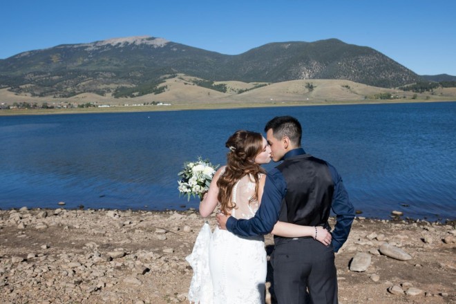 A wedding kiss in front of very blue Eagle Nest lake