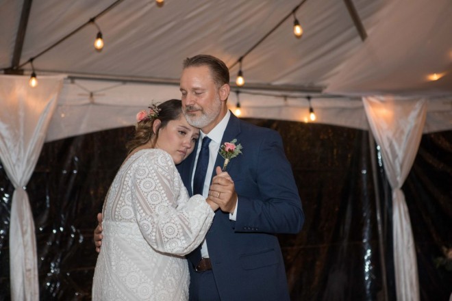Scarlet has wet eyes as she hugs her dad during their father/daughter dance