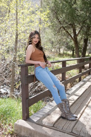 Casually leaning on a bridge, Jenica has her senior photos captured by Taos creek