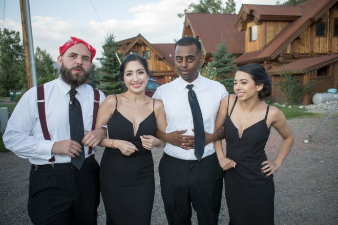 Wedding party in black, locked arms and having fun