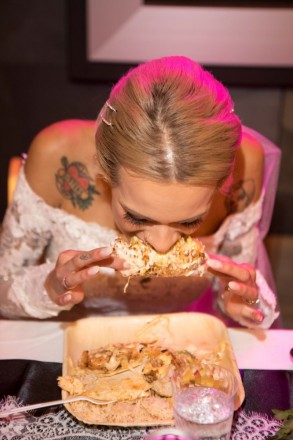 Bride, Courtney, eats corn on the cob at her wedding reception