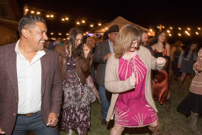 Outdoor Taos wedding on the mesa of El Prado with lights and line dancing