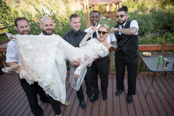 Travis and his groomsmen holds bride with sunglasses