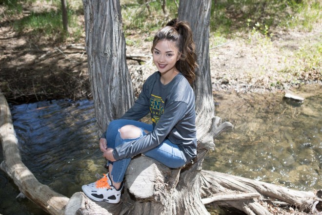 Jenica sits next to the creek in Taos Canyon for her senior photo shoot