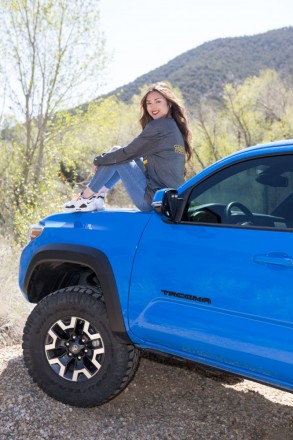 Senior, Jenica, poses on her Tacoma with the mountains adorning the background