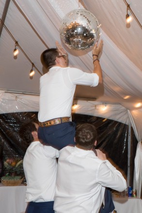 The groomsmen get the disco ball up to shine through the reception