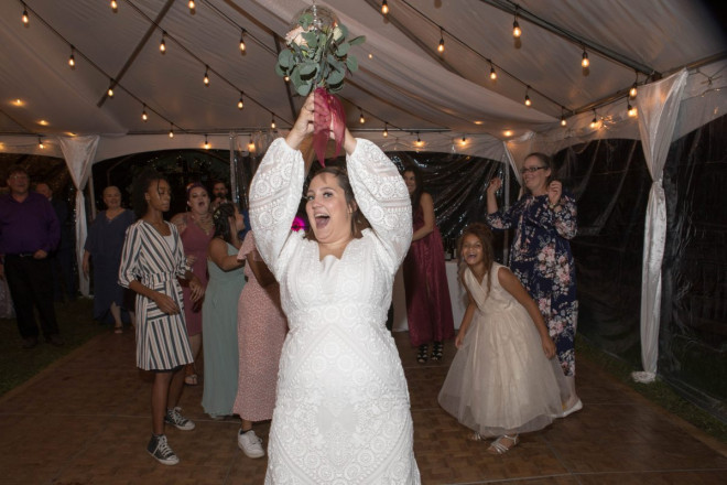 Scarlet throws her bouquet to the single ladies at her wedding