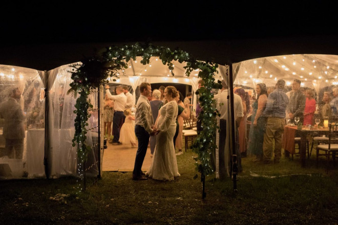 Scarlet and Craig look at one another as the reception rolls in the background