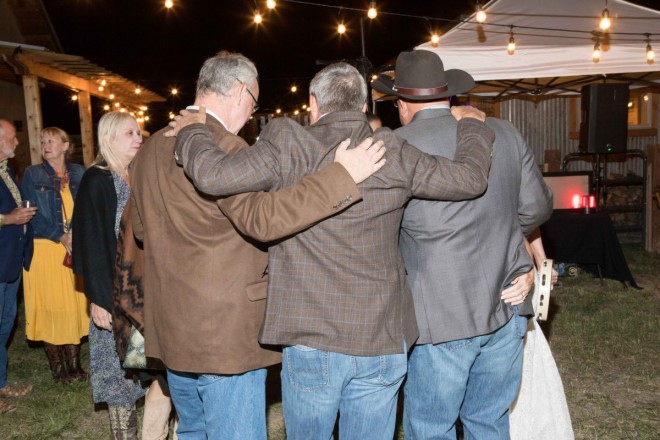The groom and his buddies sing to song during outdoor September wedding reception
