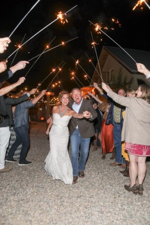 Chasity and Bill run through sparklers at the end of their Taos wedding