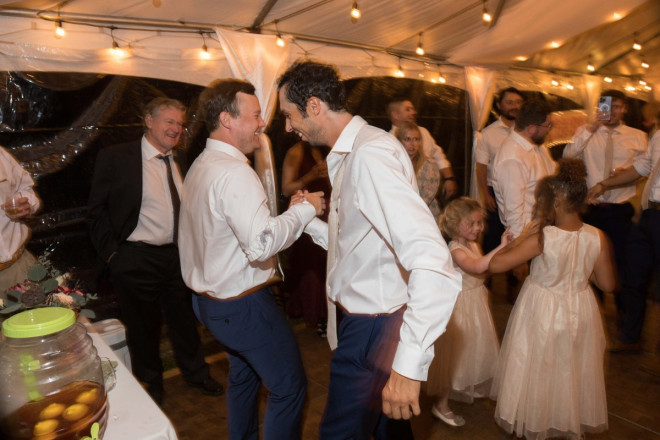 The groomsmen and and all of the guests dancing at the wedding reception