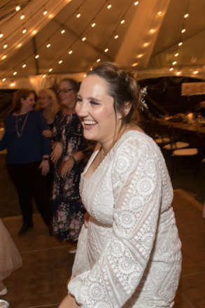 Bride laughs during her reception in a tent at her Valle Escondido wedding